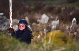 Kylie Crowder surveying with level and staff in the Burren of Co. Clare.