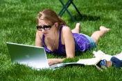 Photo of a woman studying on grass