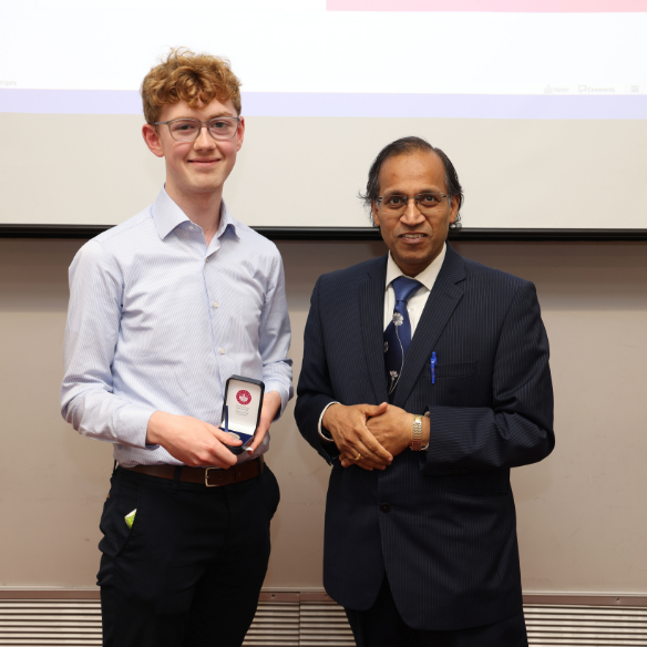 Male student receiving her award from academic
