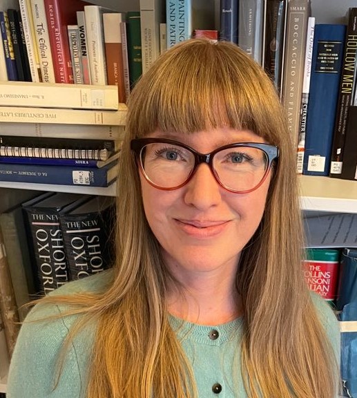 Photograph of Rhiannon Daniels in front of bookshelf