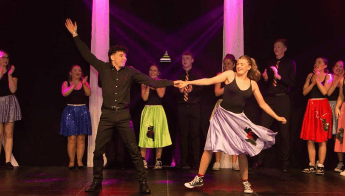 Students dancing on stage at strictly charity event