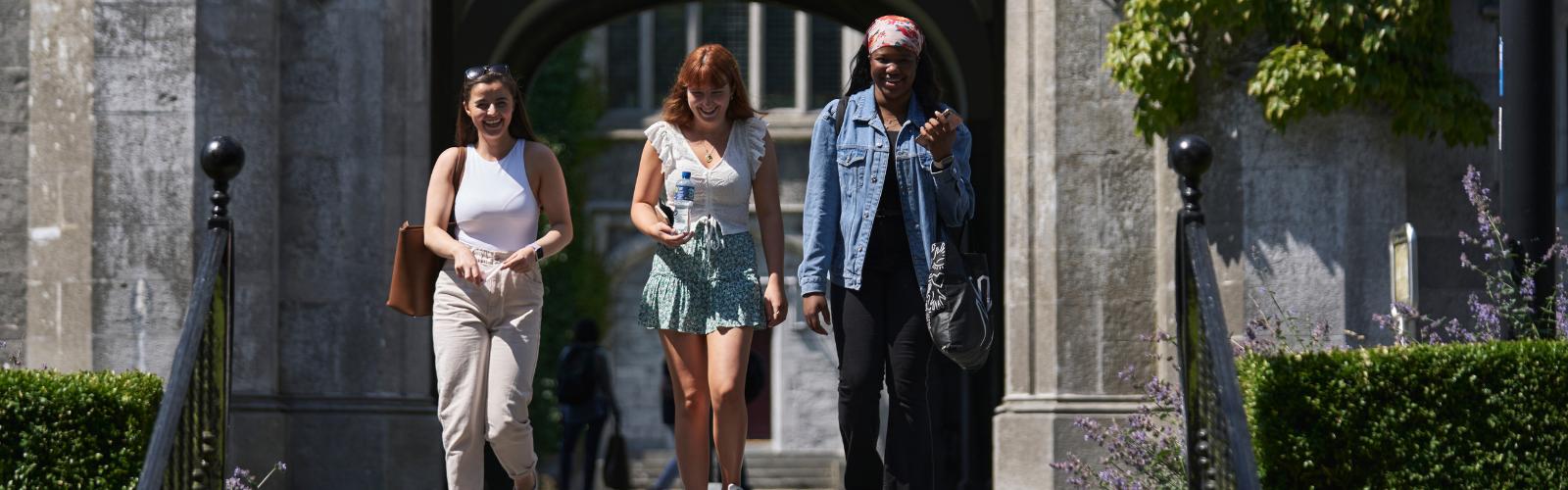 3 students walking out of the quadrangle