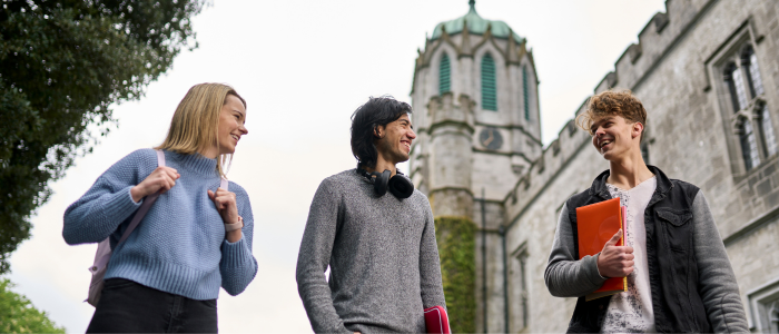 3 students walking through campus