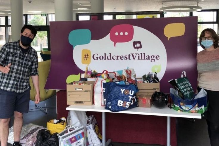 two people sorting donations in Goldcrest village